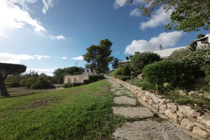 Camino empedrado y jardín de Bon Viure con la casa al fondo