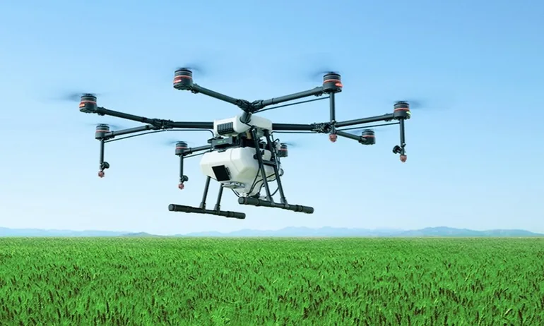 Dron agrícola de fumigación sobrevolando un campo de cultivo
