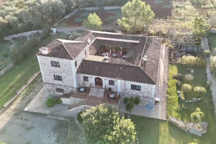 Fachada de piedra del agroturismo Ses Illes con palmeras y jardín