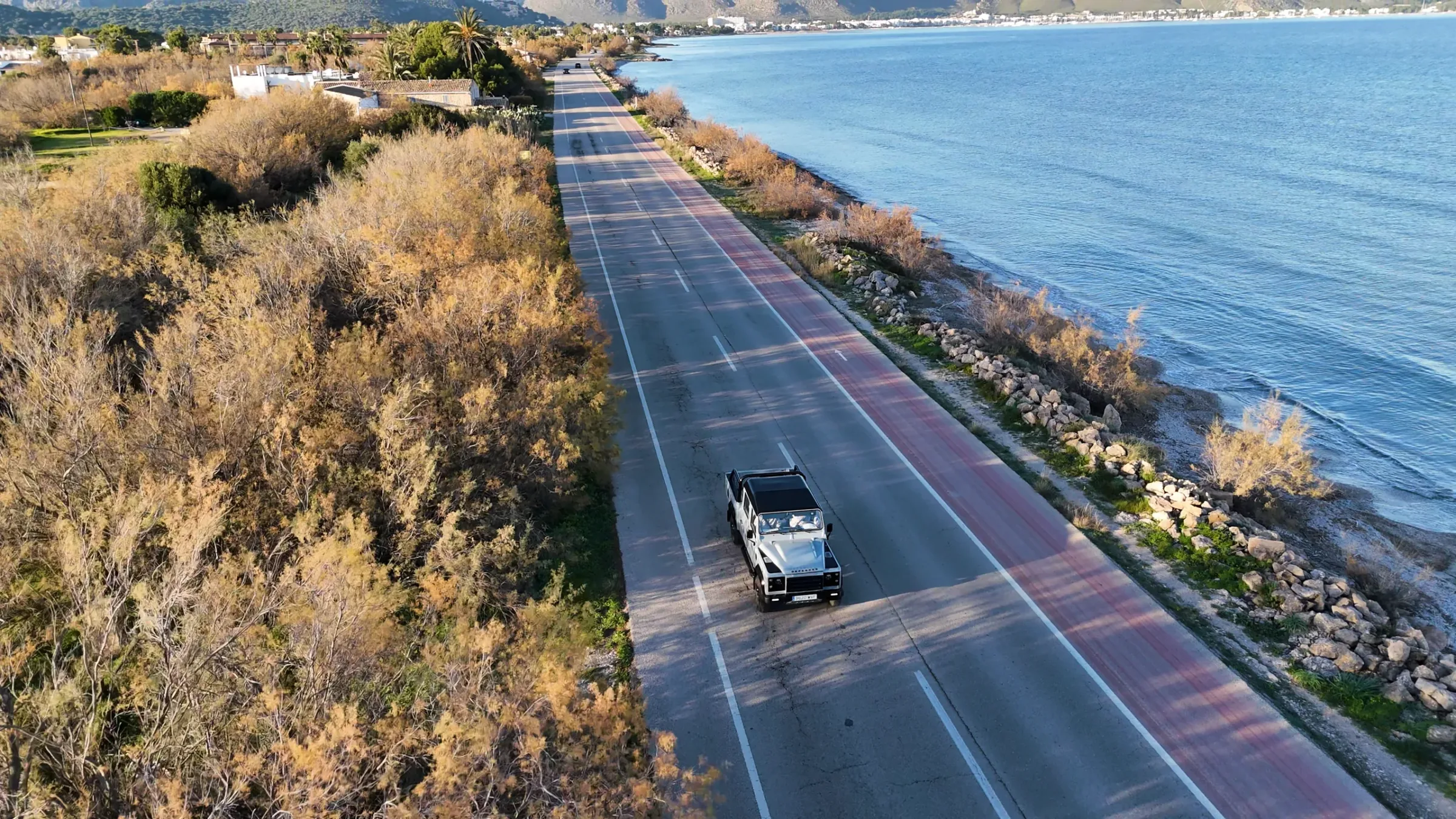 Todoterreno circulando por la carretera de costa de Mallorca visto desde un dron