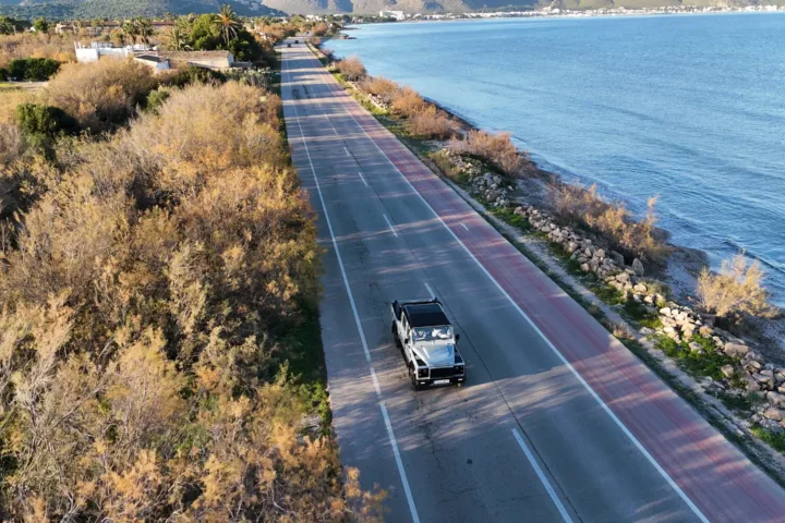 Todoterreno circulando por la carretera de costa de Mallorca visto desde un dron